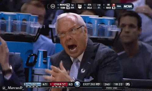 A Man In A Suit And Tie Is Screaming During A Basketball Game GIF
