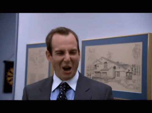 A Man In A Suit And Tie Is Screaming In Front Of A Framed Picture Of A House GIF