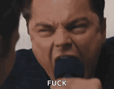 A Man In A Suit And Tie Is Screaming With His Mouth Open And Says Fuck . GIF