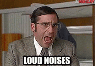 A Man In A Suit And Tie Is Screaming With His Mouth Open And The Words `` Loud Noises '' Written On His Face . GIF