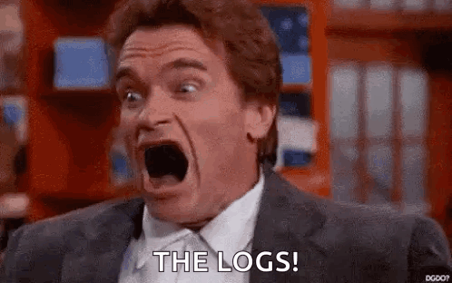 A Man In A Suit And Tie Is Screaming With His Mouth Open And The Words `` The Logs '' Written On His Face . GIF