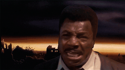 A Man In A Suit And Tie Is Screaming With His Mouth Open GIF