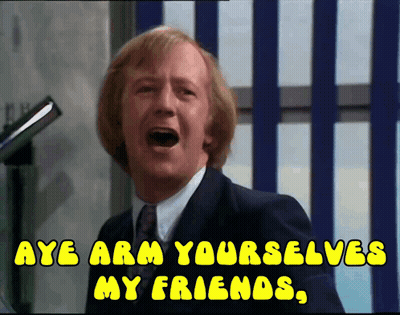 A Man In A Suit And Tie Is Screaming With The Words Aye Arm Yourselves My Friends GIF