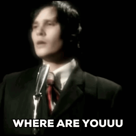 A Man In A Suit And Tie Is Singing Into A Microphone And The Words `` Where Are Youu '' Are Written Below Him . GIF