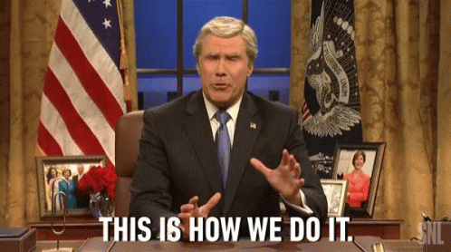 A Man In A Suit And Tie Is Sitting At A Desk And Saying This Is How We Do It GIF