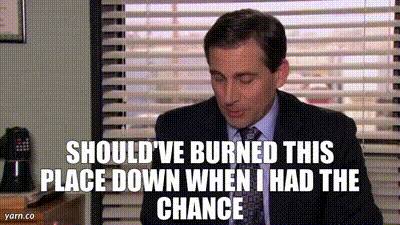 A Man In A Suit And Tie Is Sitting At A Desk . GIF