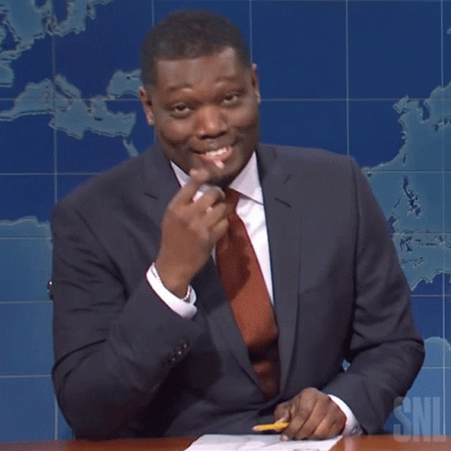 A Man In A Suit And Tie Is Sitting At A Desk With A Pencil In Front Of A Map That Says Snl GIF