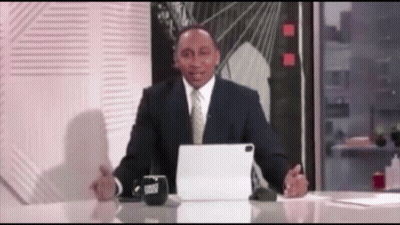 A Man In A Suit And Tie Is Sitting At A Desk With A Tablet And A Cup That Says Trust On It GIF