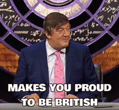 A Man In A Suit And Tie Is Sitting At A Desk With The Words Makes You Proud To Be British Below Him GIF
