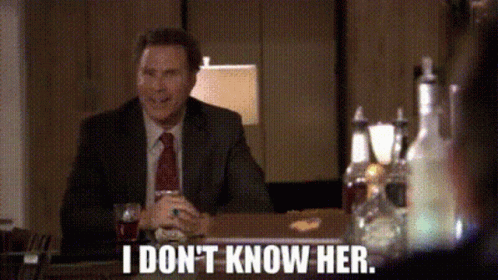 A Man In A Suit And Tie Is Sitting At A Table And Says I Don 'T Know Her . GIF