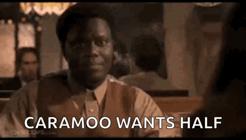 A Man In A Suit And Tie Is Sitting At A Table With A Woman And Says `` Caramoo Wants Half '' . GIF
