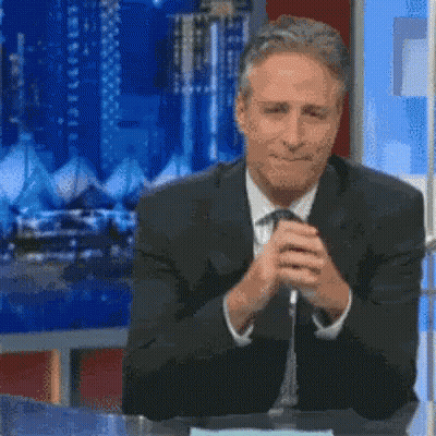 A Man In A Suit And Tie Is Sitting At A Table With The Words " I Wish " Written On It GIF