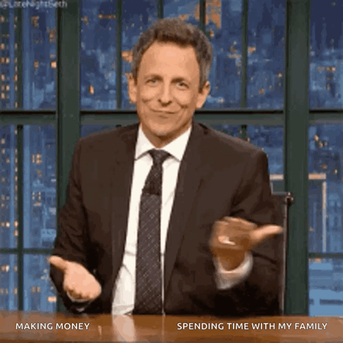 A Man In A Suit And Tie Is Sitting At A Table With The Words Making Money Spending Time With My Family On The Bottom GIF