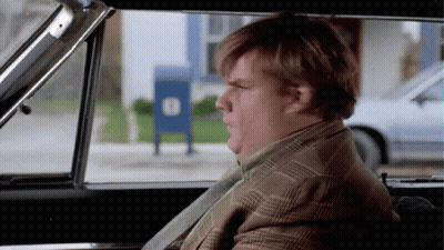 A Man In A Suit And Tie Is Sitting In A Car Looking Out The Window .. GIF