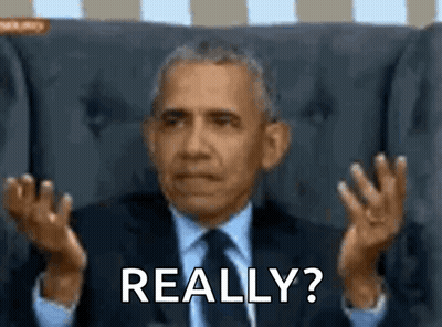 A Man In A Suit And Tie Is Sitting In A Chair And Making A Funny Face While Saying Really ? GIF