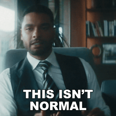 A Man In A Suit And Tie Is Sitting In A Chair And Says This Isn 'T Normal GIF