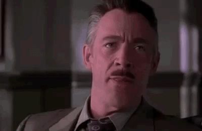 A Man In A Suit And Tie Is Sitting In A Chair And Talking To Someone . GIF