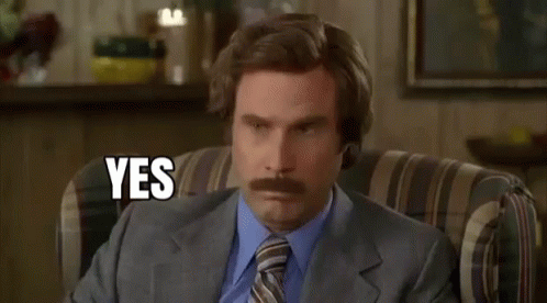 A Man In A Suit And Tie Is Sitting In A Chair With His Eyes Closed And Says Yes . GIF