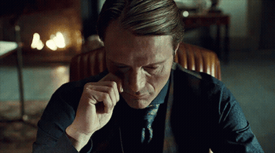 A Man In A Suit And Tie Is Sitting In A Chair With His Eyes Closed GIF