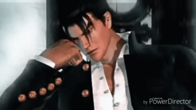 A Man In A Suit And Tie Is Sitting In A Chair With His Hand On His Face . GIF