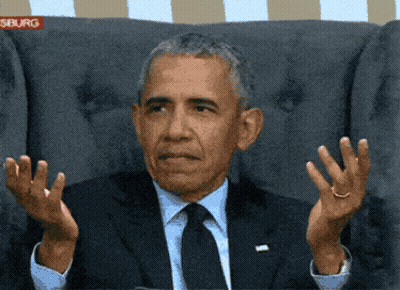 A Man In A Suit And Tie Is Sitting In A Chair With His Hands Outstretched In Front Of A Sign That Says Siburg GIF
