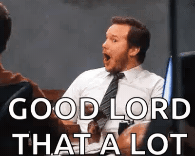 A Man In A Suit And Tie Is Sitting In A Chair With His Mouth Open And Says `` Good Lord That A Lot '' GIF