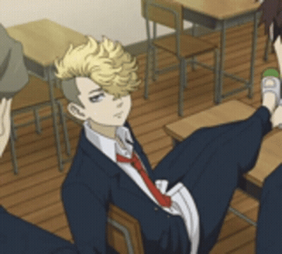 A Man In A Suit And Tie Is Sitting In A Classroom With Other Students . GIF