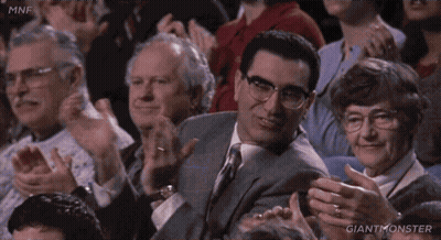 A Man In A Suit And Tie Is Sitting In A Crowd Clapping And Says That 'S My Dog . GIF