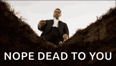 A Man In A Suit And Tie Is Sitting In A Grave With The Words Nope Dead To You Above Him . GIF