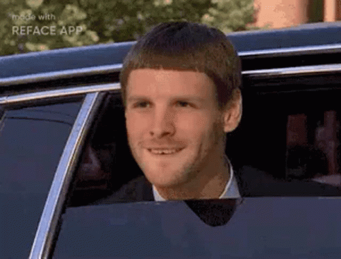 A Man In A Suit And Tie Is Sitting In A Limousine And Smiling . GIF