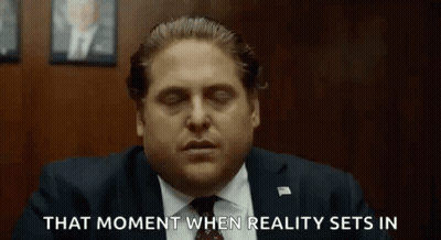 A Man In A Suit And Tie Is Sitting In A Room With His Eyes Closed And Says That Moment When Reality Sets In GIF
