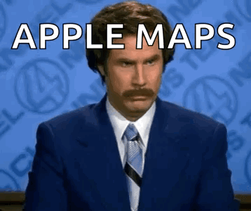 A Man In A Suit And Tie Is Sitting In Front Of A Blue Background With The Words Apple Maps Written On It . GIF