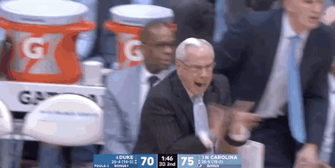 A Man In A Suit And Tie Is Sitting In Front Of A Gatorade Cart GIF