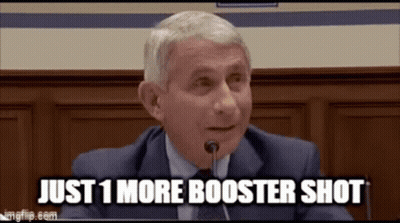 A Man In A Suit And Tie Is Sitting In Front Of A Microphone . GIF