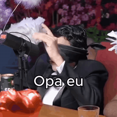 A Man In A Suit And Tie Is Sitting In Front Of A Microphone With The Words Opa Eu Written On The Screen GIF