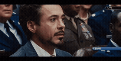 A Man In A Suit And Tie Is Sitting In Front Of A Screen That Says Cspan GIF