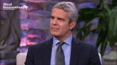 Man In Suit Sitting In Front Of Screen GIF