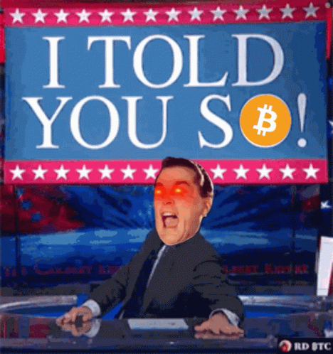 A Man In A Suit And Tie Is Sitting In Front Of A Sign That Says I Told You So GIF