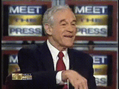 A Man In A Suit And Tie Is Sitting In Front Of A Wall That Says Meet Press GIF