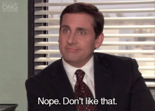 A Man In A Suit And Tie Is Sitting In Front Of A Window And Saying Nope . Don 'T Like That . GIF