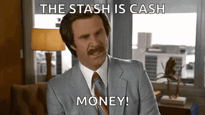 A Man In A Suit And Tie Is Sitting In Front Of A Window And Saying `` The Stash Is Cash Money '' . GIF