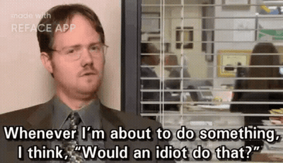 A Man In A Suit And Tie Is Sitting In Front Of A Window And Talking . GIF