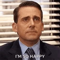 A Man In A Suit And Tie Is Sitting In Front Of A Window With Blinds And Saying I 'M So Happy . GIF