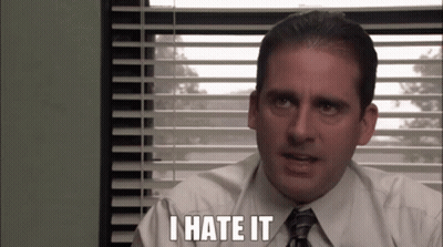 A Man In A Suit And Tie Is Sitting In Front Of A Window With Blinds And Says `` I Hate It '' . GIF