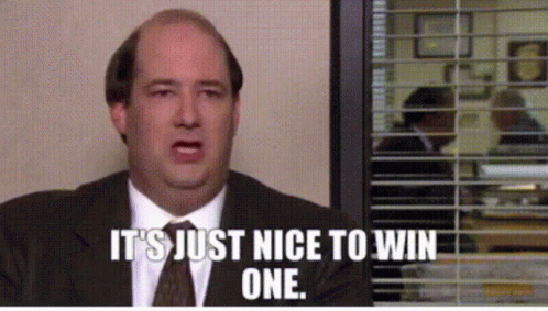 A Man In A Suit And Tie Is Sitting In Front Of A Window With Blinds And Says It 'S Just Nice To Win One GIF