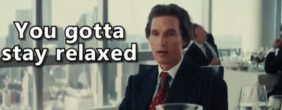 A Man In A Suit And Tie Is Sitting In Front Of A Window With The Words " You Gotta Stay Relaxed " Above Him GIF