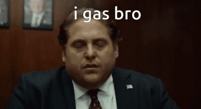 A Man In A Suit And Tie Is Sitting In Front Of A Wooden Wall With His Eyes Closed . GIF