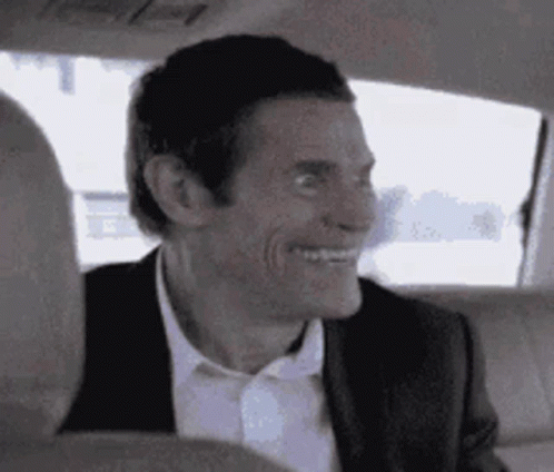 A Man In A Suit And Tie Is Sitting In The Back Seat Of A Car . GIF