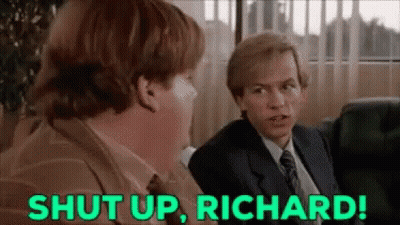 A Man In A Suit And Tie Is Sitting Next To Another Man In A Chair And Says `` Shut Up , Richard '' . GIF