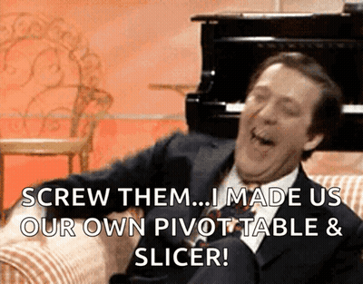 A Man In A Suit And Tie Is Sitting On A Couch And Laughing GIF